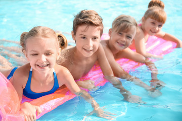 Fototapeta na wymiar Cute children swimming in pool on summer day