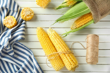 Ripe corn cobs on wooden background