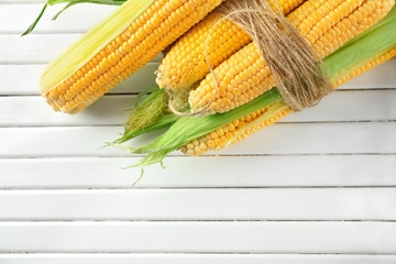 Ripe corn cobs on wooden background