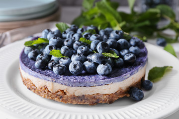 Delicious cheesecake with blueberries on plate, closeup