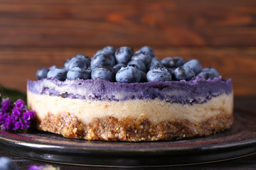 Delicious cheesecake with blueberries on plate, closeup