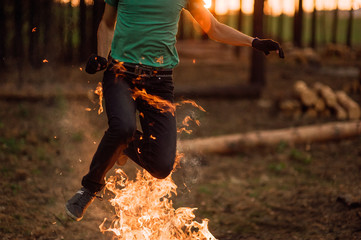 man is jumping over a fire