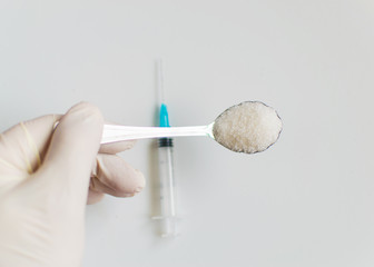 A spoonful of sugar and a syringe. The concept of harm to sugar and the onset of diabetes.