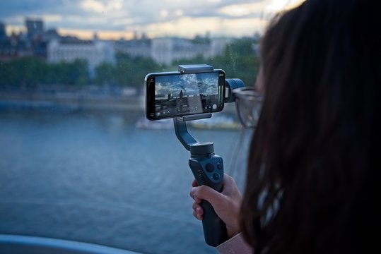 Girl Records video with her mobile phone on a gimbal in London