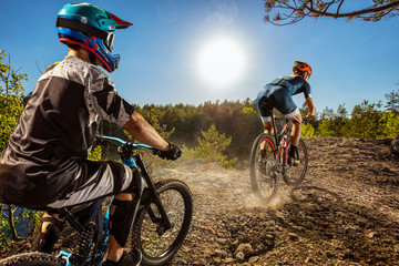 Two bikers on trail. Male cyclists rides the rock. Mountain Bike. Cross-Country Cycling
