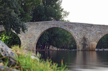 Fototapeta na wymiar Ancient stone bridge over river