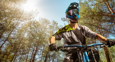 Mountain biker on forest trail. Male cyclist portrait in sport helmet