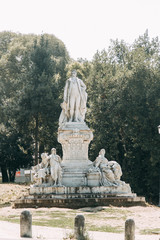 Fototapeta premium Sculptures in the parks of Rome, nature and architecture. Ancient monuments of culture. Arches and columns, fountain and lake. Flowering plant
