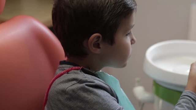 Little boy in dentist sit on chair with an open mouth