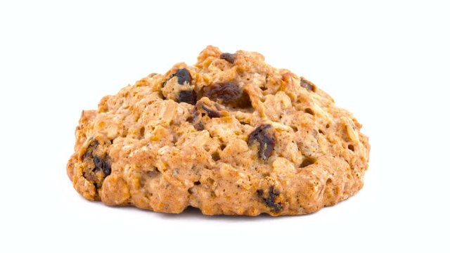 Macro of a full frame one oatmeal raisin cookie rotating on the turntable. Isolated on the white color background.