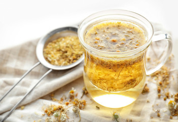 Glass cup of chamomile tea on table, closeup