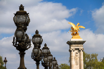 Fototapeta na wymiar Ornate lanterns and statue at the Pont Alexandre III in Paris, France
