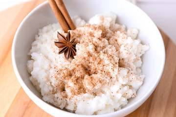 Bowl with delicious rice pudding and cinnamon powder, closeup
