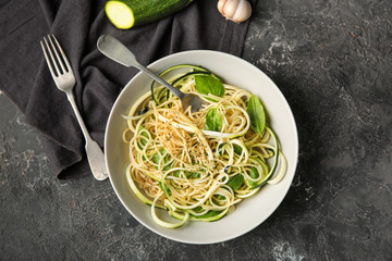 Plate of spaghetti with zucchini on table