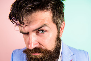 Keep hair tidy and care about hairstyle. Man bearded hipster on strict face pink blue background....