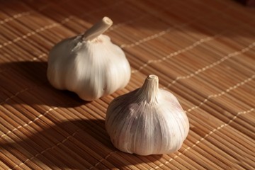 Two Bulbs of Fresh Garlic on Bamboo Mat