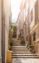 narrow steep alley with steps in historic spanish village on island of Mallorca