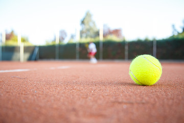 Tennis ball on the floor of a tennis court in a match in the shade. 