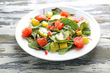 Plate with healthy fresh salad on wooden table