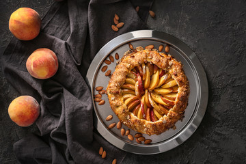 Plate with delicious peach galette on grunge table