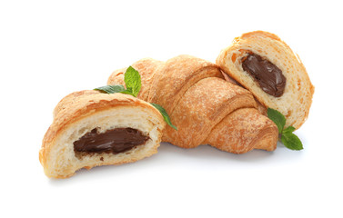 Tasty croissants with chocolate cream on white background