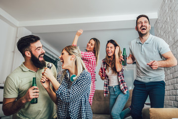 Group of friends playing karaoke at home. Concept about friendship, home entertainment and people