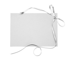 Blank paper card with silver ribbon and bow on white background