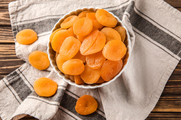 Bowl with dried apricots on table