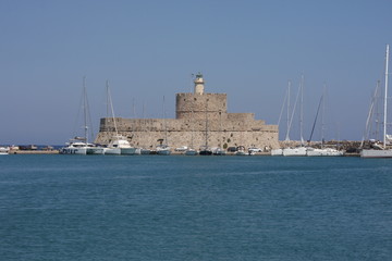 The Gate of Marina in Rhodes Island with fort and lighthouse