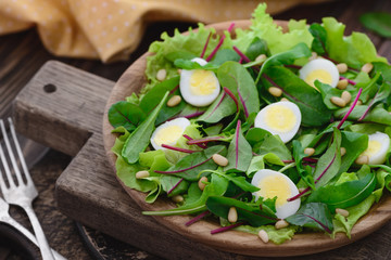 Fresh spring appetizing quail eggs, pine nuts, arugula swiss chard salad