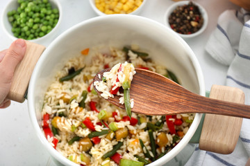 Cooking of tasty rice with vegetables in saucepan