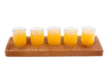 Yellow, same color opaque cocktails, a set of shots in one row, five servings on a wooden stand, substrate. Side view Isolated white background. Drink for the menu restaurant, bar, cafe