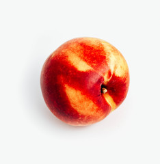 Ripe yellow and red colored delicious nectarine, isolated on white background, natural shadow.