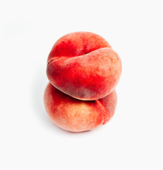 Saturn Peach isolated on white background. Flat peaches, two doughnut peaches in a pile.