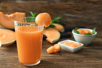 Glass with delicious melon smoothie on wooden table