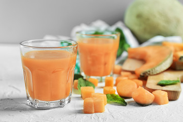 Glasses with delicious melon smoothie on white table