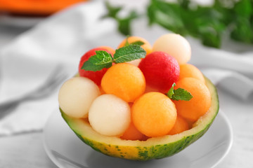 Bowl with fresh melon and watermelon balls on light table