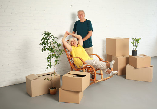 Happy Mature Couple With Boxes After Moving Into New House