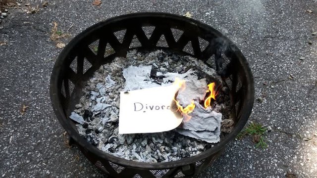 Burning negative messages written on paper in fire pit