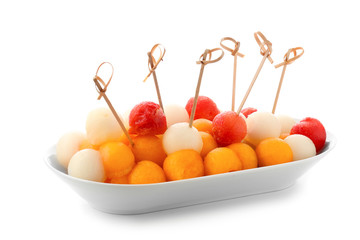 Plate with tasty melon balls on white background