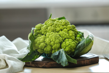 Green cauliflower on wooden board