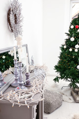 Decorative fireplace with burning candles and garland indoors