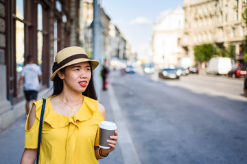 Fototapeta premium Girl walking on the street with coffee to go