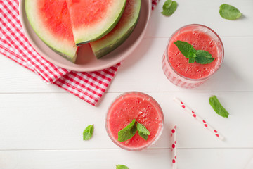 Glasses with fresh watermelon smoothie on white table