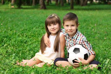 Cute little children with ball in park on summer day