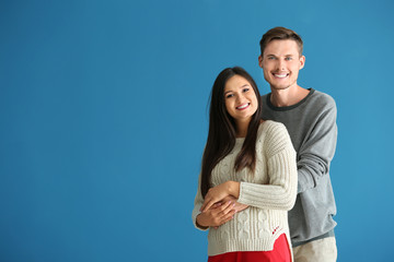Portrait of cute young couple on color background