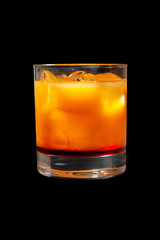 Multi-colored two-layer opaque cocktail in a low glass with ice cubes with melon, pear, apple, berries, fruit, pineapple, orange, apricot, peach. Side view Isolated black background Drink for the menu