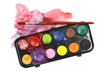 Watercolor pallet and paintbrushes isolated on white, top view