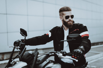 Biker In A Sunglasses Is Sitting On Motorcycle.