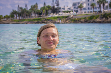 Portrait of an attractive blonde woman with blue eyes in clear blue water